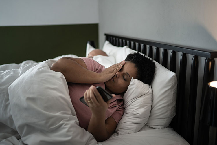Woman in bed holding phone